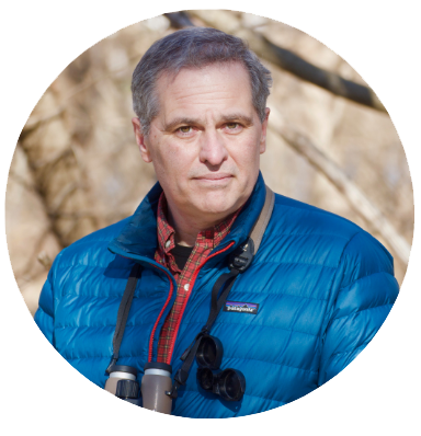 Portrait of a man, Ian Owens, in a blue shirt and black jacket.